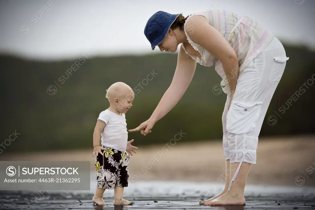 Young toddler at the beach with his mother.