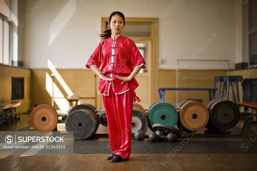 Teenage girl performing martial arts in a gym.