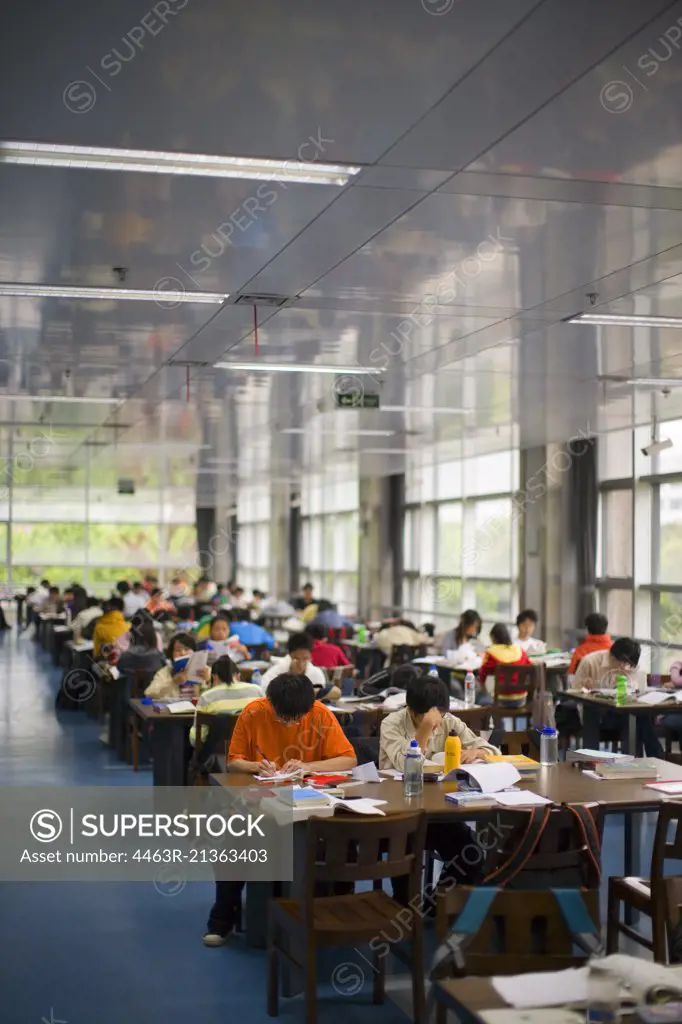 Teenagers sitting in a study hall of a school.