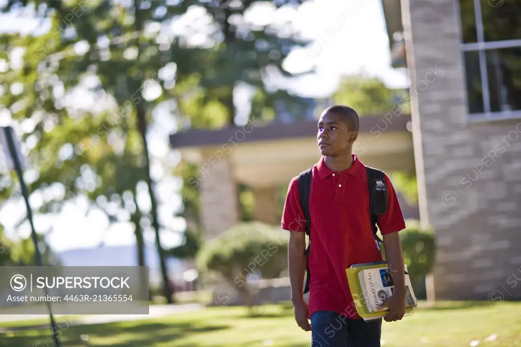 Teenage boys walking away from school with textbooks