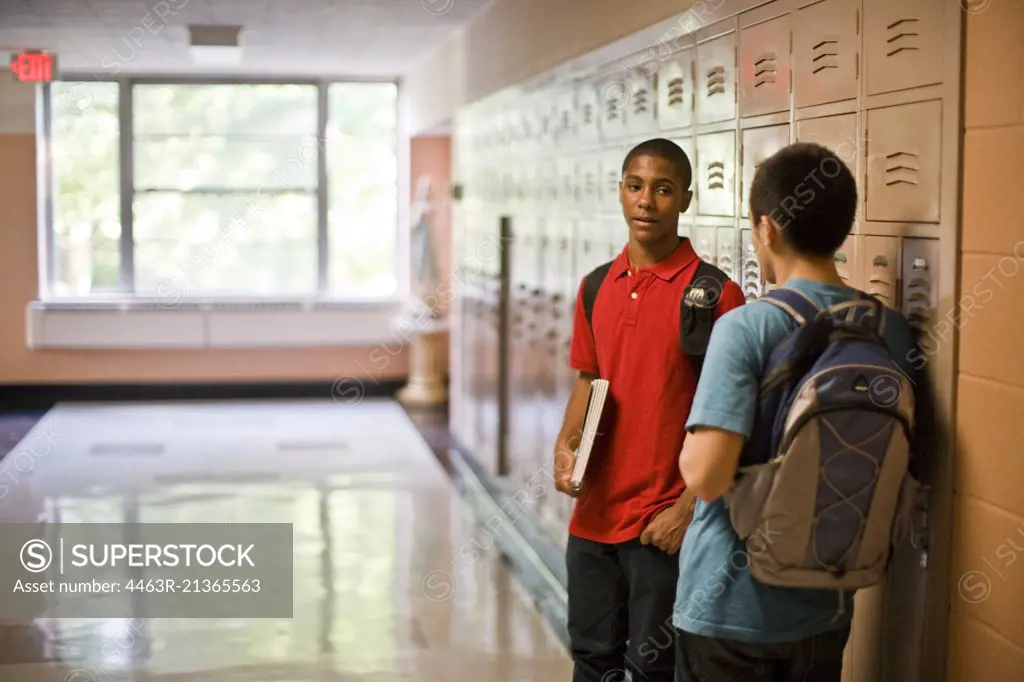 Teenage boys talking in school corridor