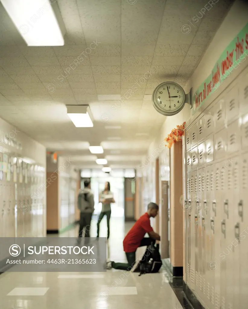 Boy getting something out of his locker at school.