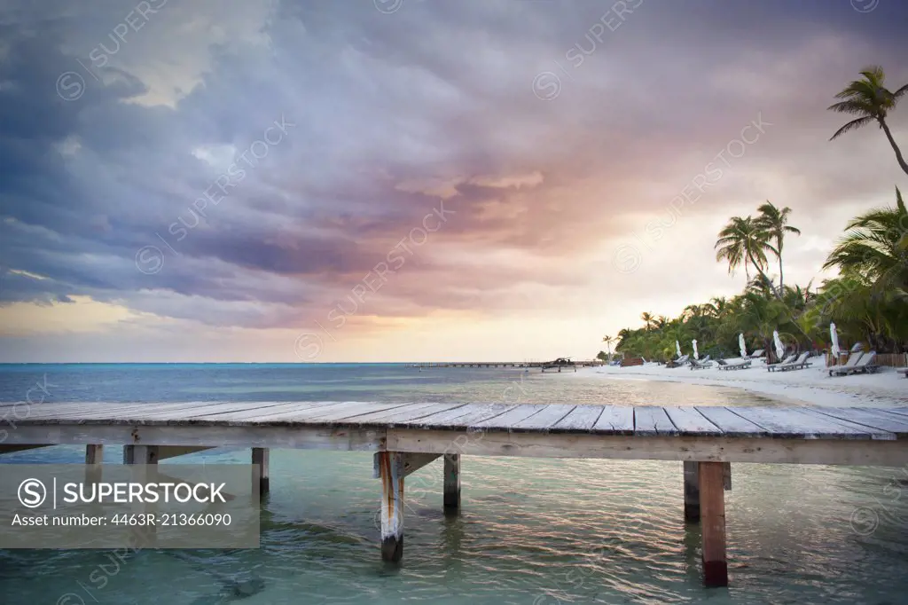 Wooden jetty on a tropical island at sunset.