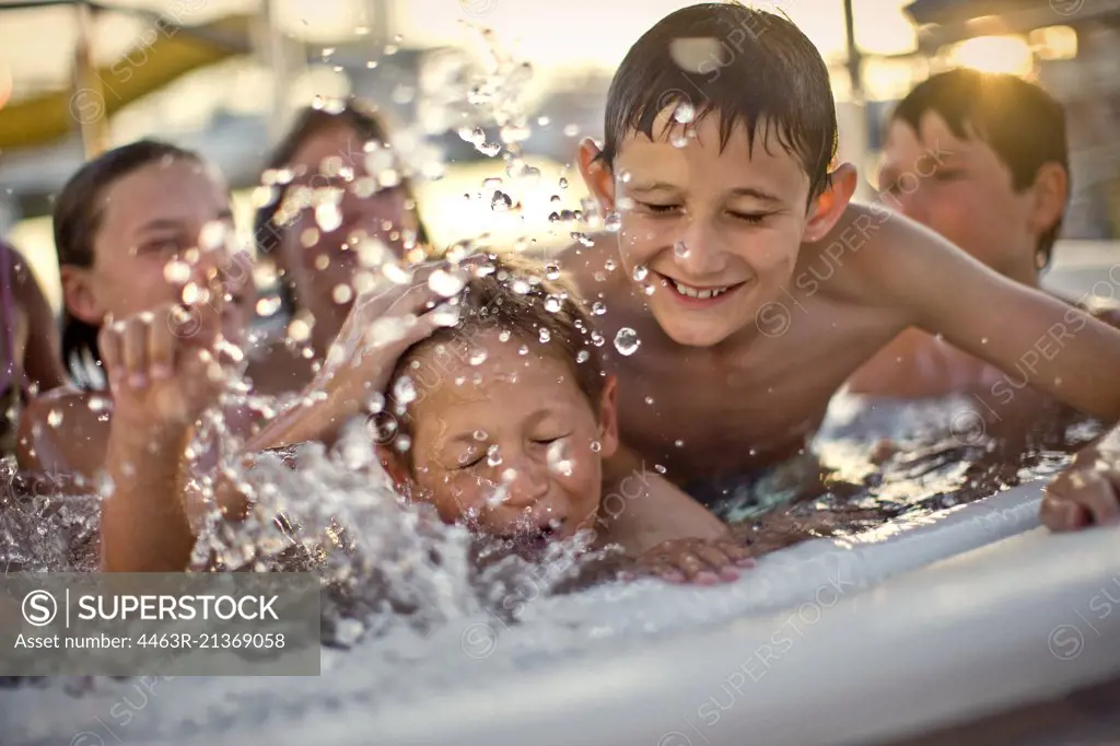 Group of children having fun playing together in a hot tub.