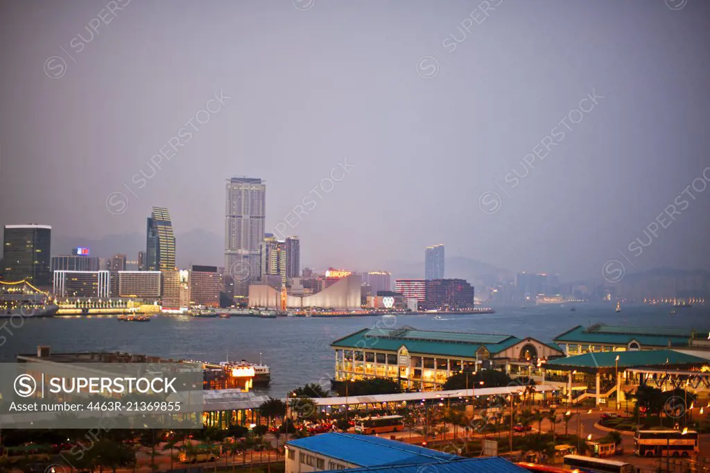 Tranquil view of a city skyline and harbor at night.