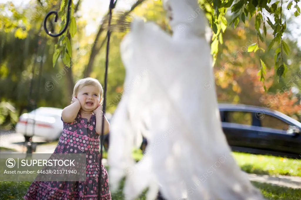 Toddler girl scared by Halloween decoration