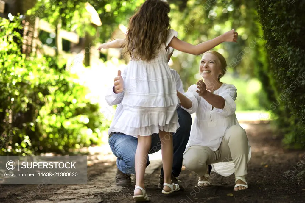 Young girl runs towards her grandparents on a quiet country road.