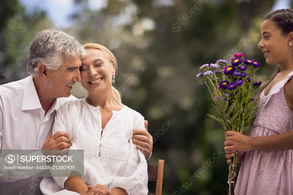 Young girl presents her grandmother a bunch of flowers.