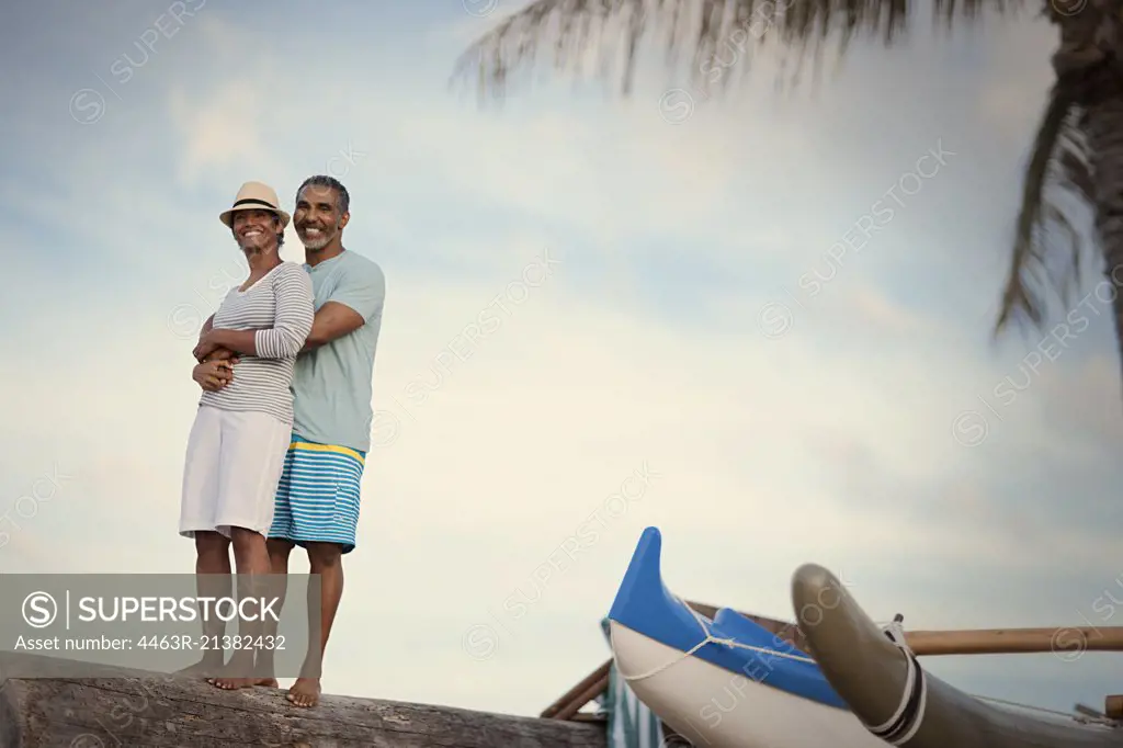 Portrait of mature couple hugging at beach. 