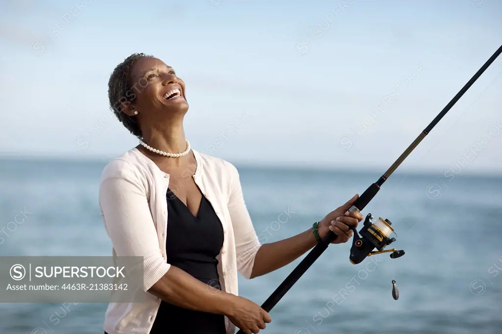 Mature woman enjoying fishing.