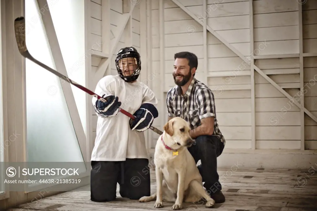 Portrait of young hockey player standing with his dad, 