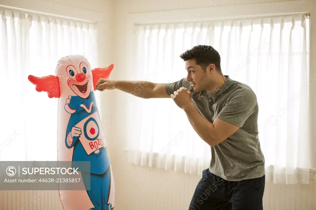 Active young man training with a punching bag.