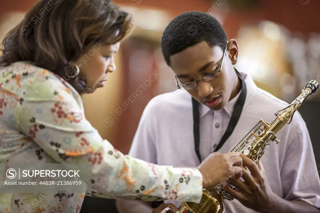 Teenage boy learning to play saxophone.