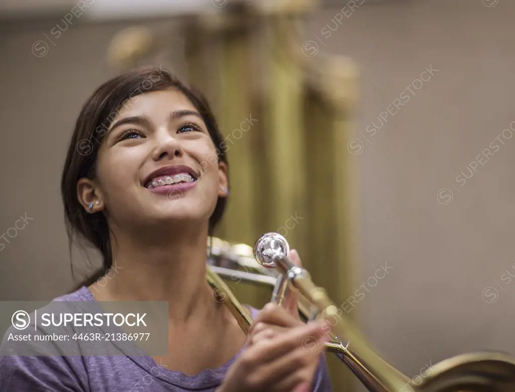 Teenage girl learning to play trombone.