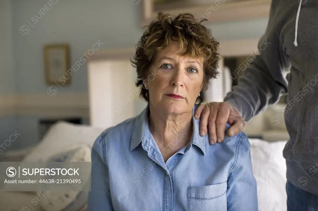 Portrait of a depressed mature woman sitting sadly on her bed.