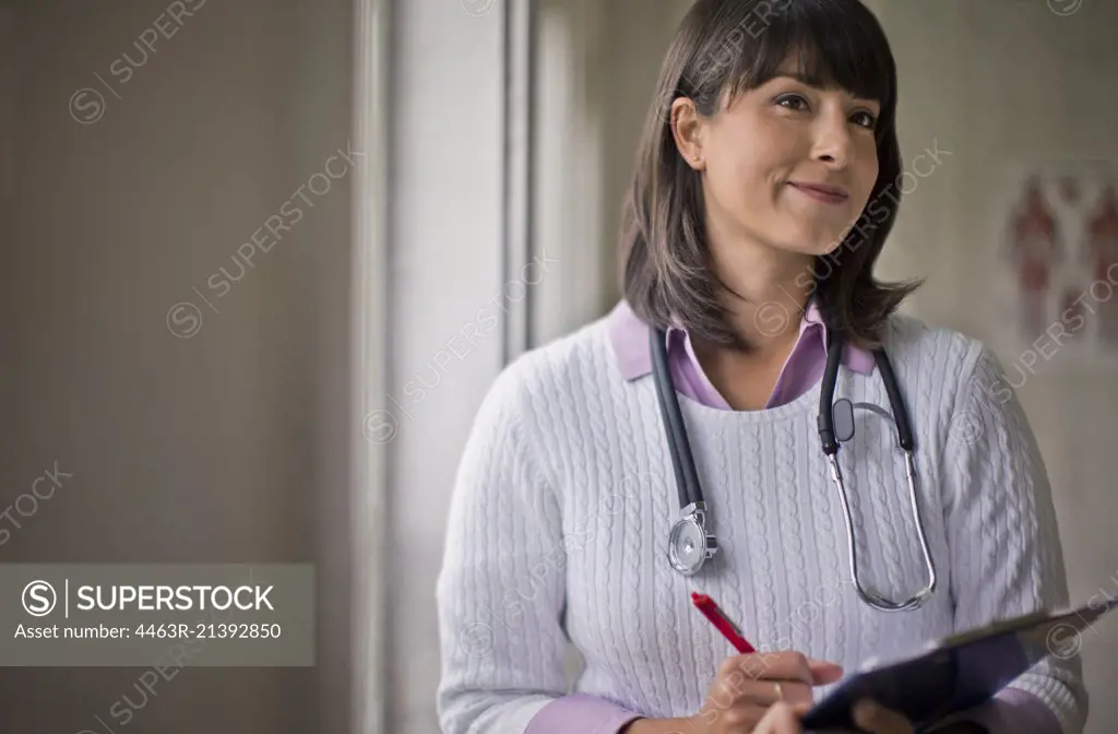 Portrait of a young female doctor holding a clipboard in her office.