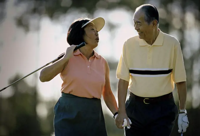 Mature couple having fun while playing golf together.