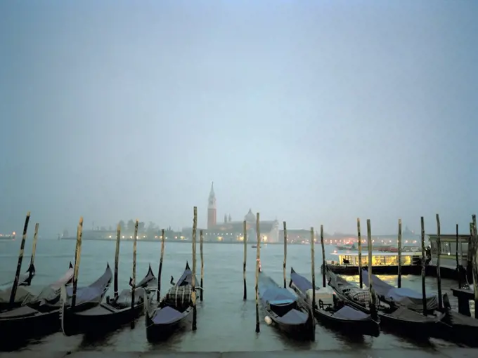 Gondolas moored at a waterfront, Venice, Italy.