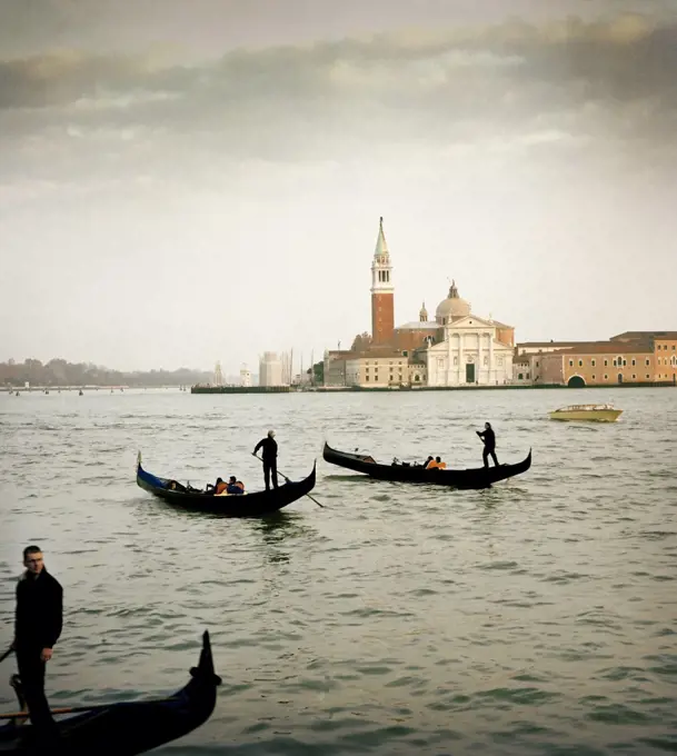 Gondolas on the water with Giudecca Island in the background, Venice, Italy.