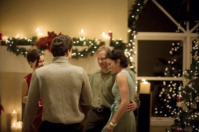 Group of mid-adult friends having fun at a Christmas party.