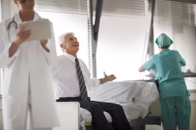 View of a man sitting on a bed with medical care.