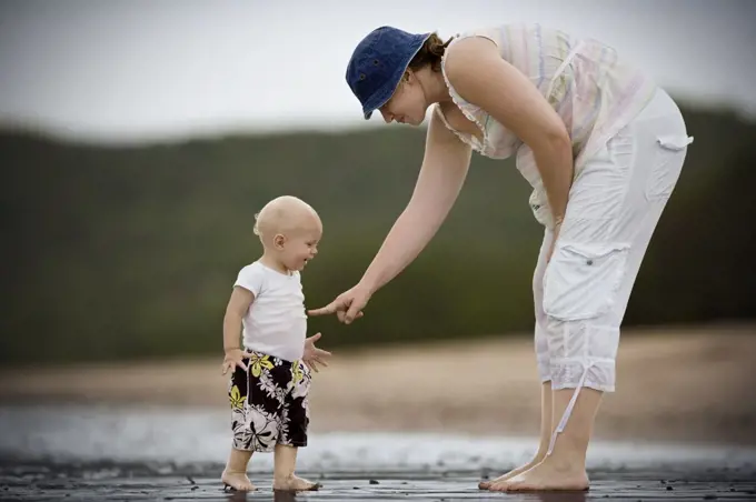 Young toddler at the beach with his mother.