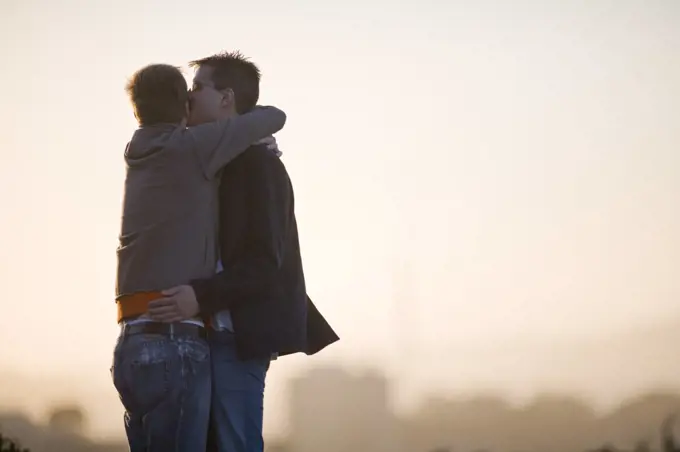 Young homosexual couple hugging.