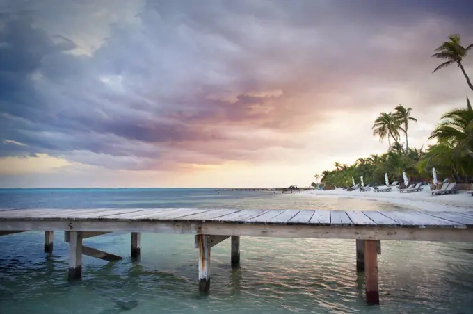 Wooden jetty on a tropical island at sunset.