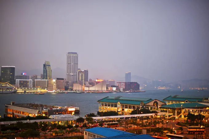 Tranquil view of a city skyline and harbor at night.