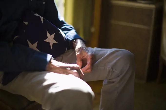 Senior man with a folded American flag