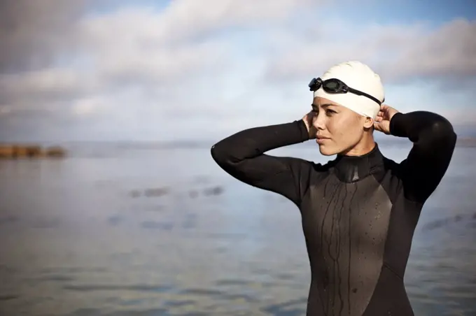 Young female athlete preparing to swim at the beach