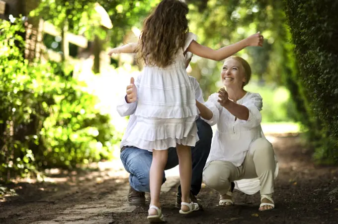 Young girl runs towards her grandparents on a quiet country road.