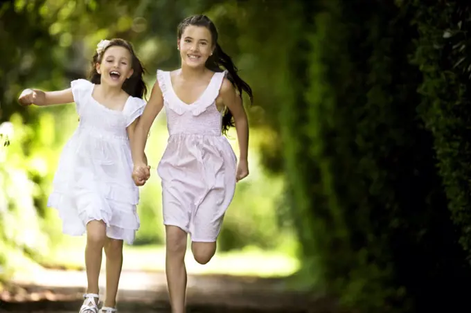 Young girls run up a quiet county road.