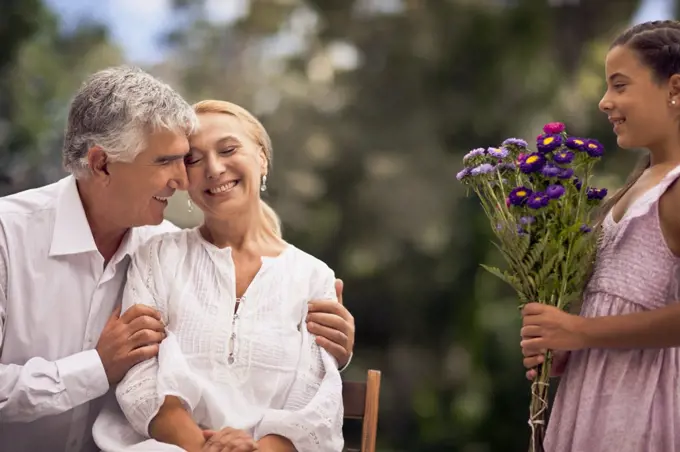 Young girl presents her grandmother a bunch of flowers.