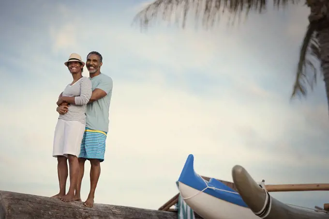 Portrait of mature couple hugging at beach. 