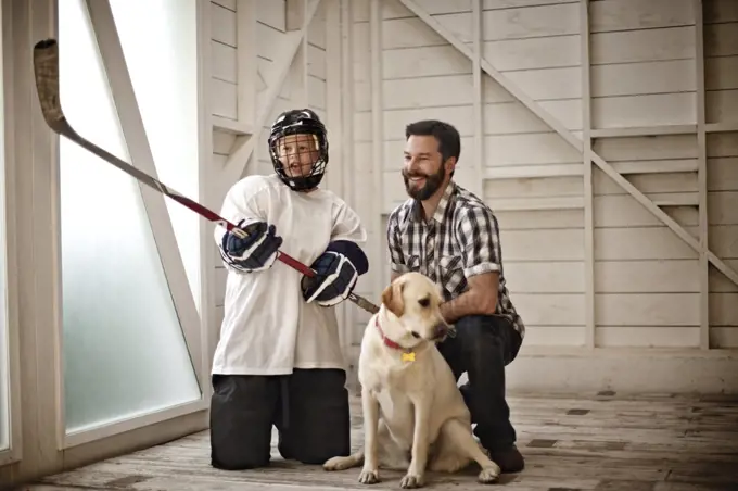 Portrait of young hockey player standing with his dad, 