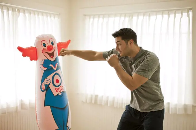 Active young man training with a punching bag.