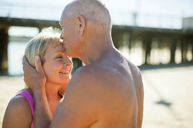 Senior couple embracing on a beach.