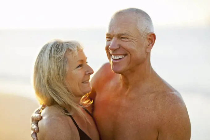 Senior couple embracing on a beach.