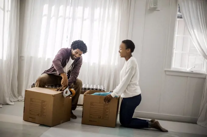 Happy couple packing boxes for a move.