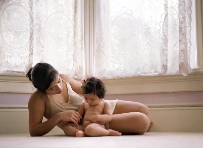 A mother is playing with her baby.