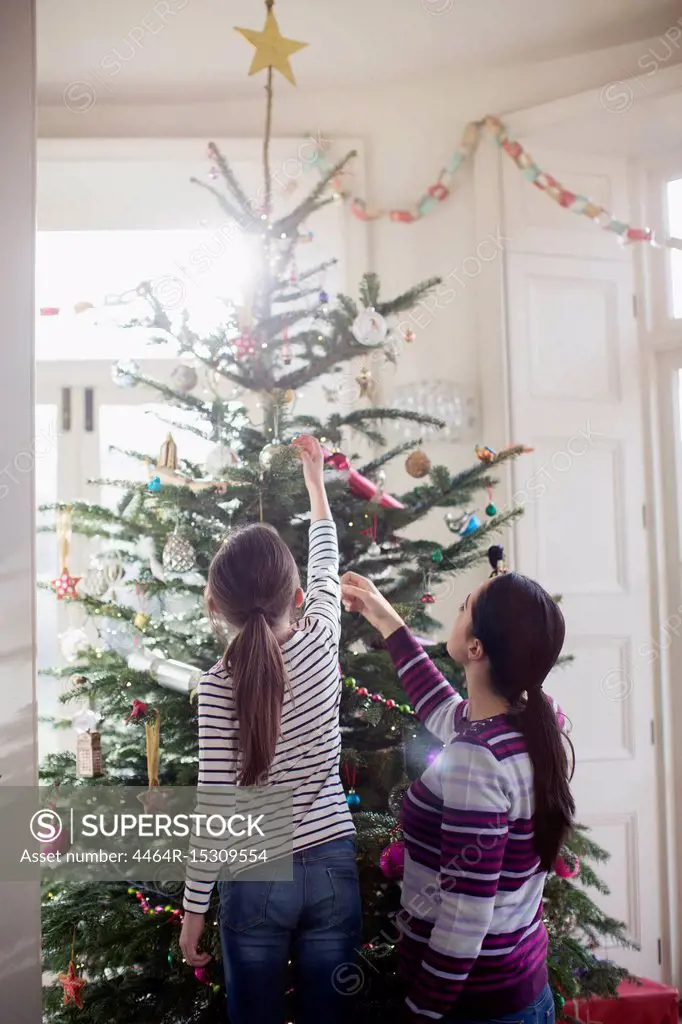 Mother and daughter decorating Christmas tree