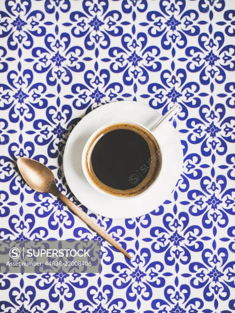 Cup of black Turkish or Eastern style coffee over oriental Moroccan patterned background, top view