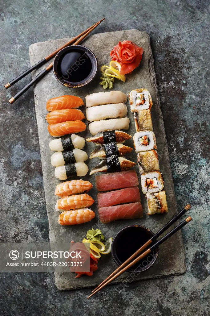 Sushi Set nigiri and sushi rolls served for two on gray stone slate on metal background