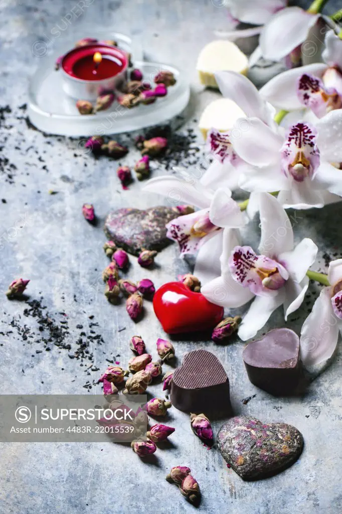 Chocolate candies heart shaped with dry tea roses and orchids for Valentine's Day.