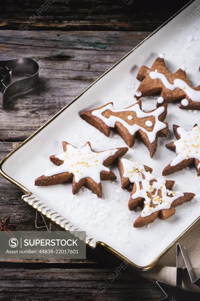 Plate with christmas cookies on old wooden table.