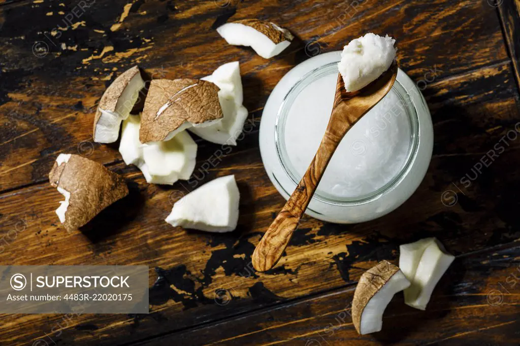 Organic healthy Coconut butter and fresh coconut pieces on wooden background