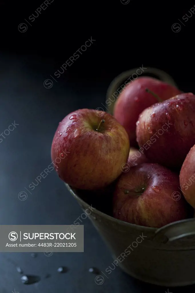 Fresh red apples in a bowl on a dark background