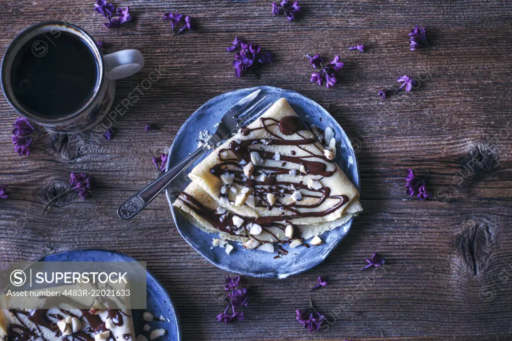 Crepes with dark chocolate drizzle and Brazil nuts