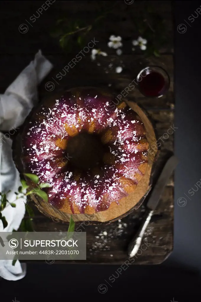 Bundt cake with blackberry glaze and white chocolate flakes